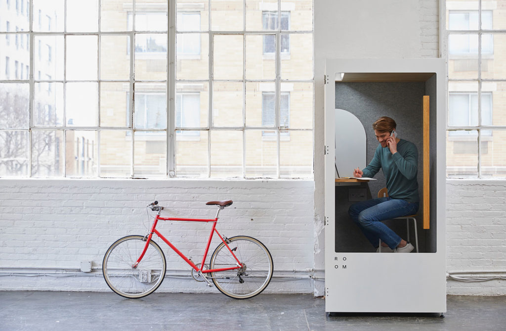 Mann in Telefonzelle mit rotem Fahrrad